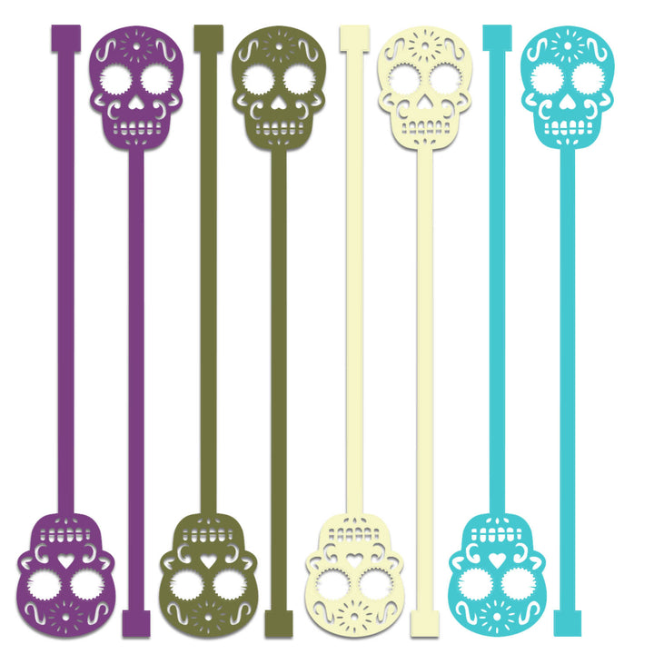Set of eight halloween skull-shaped stir sticks in purple, green, yellow, and teal. fall barware