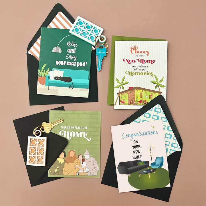 Collection of greeting cards and keychains for new home celebrations on a brown background