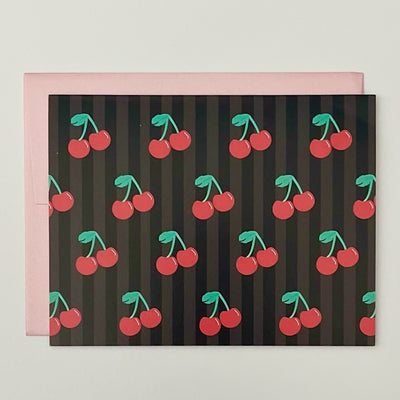 Experience a touch of nostalgia with our Retro Cherry Folded Notecard. The bold black background enhances the whimsical cherry design, making it a unique statement piece. With a blank inside, let your personal message shine. Includes a pretty pink envelope for a complete touch.