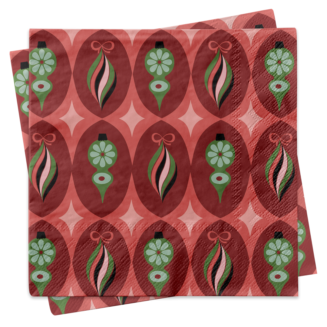 A stack of square paper napkins featuring a retro 1970s-style holiday ornament pattern in red, pink, green, and black on a white background.