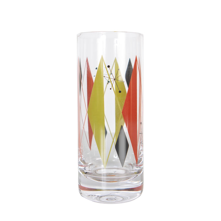 A tall highball or Collins cocktail glass with a vintage-inspired geometric diamond and starburst pattern in red, pink, and green colors.