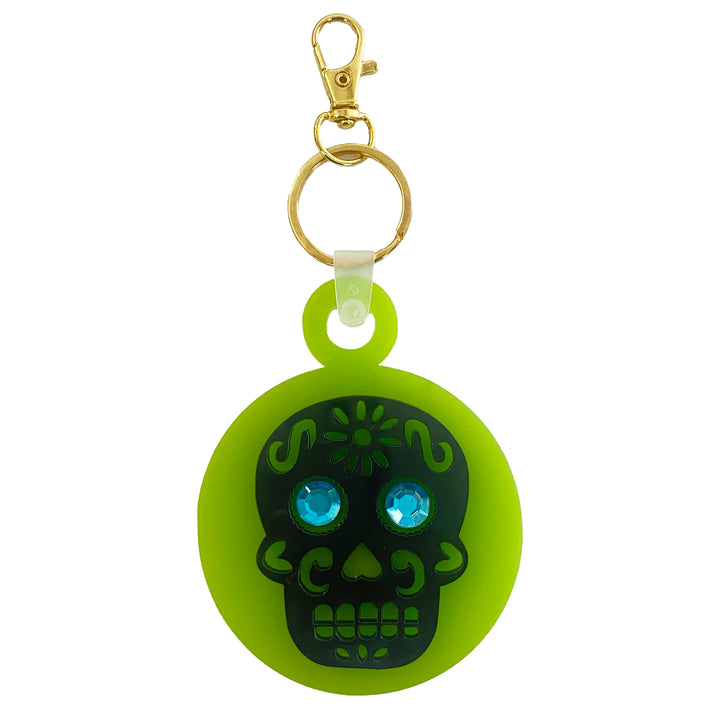 A lime green acrylic keychain with a black skull design and blue rhinestone eyes, attached to a gold-plated lobster claw keyring.